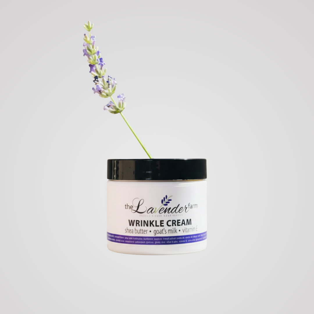 The Lavender Farm wrinkle cream in a white jar with shea butter, goat's milk and vitamin E, with a lavender sprig